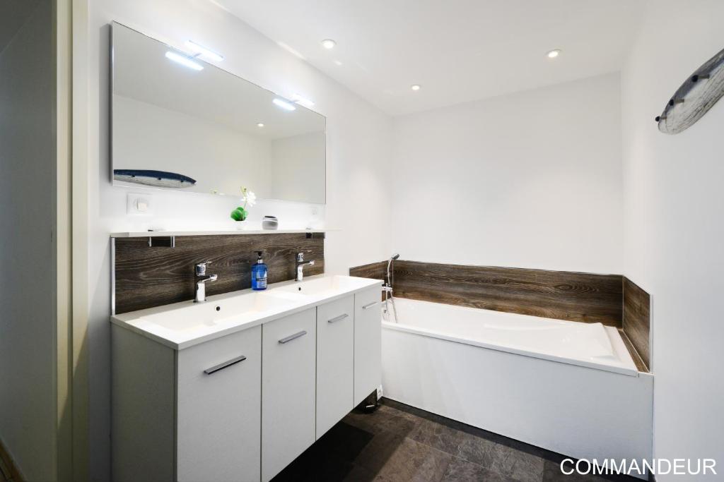 a bathroom with two sinks and a bath tub at Aux Premières Loges in Fécamp