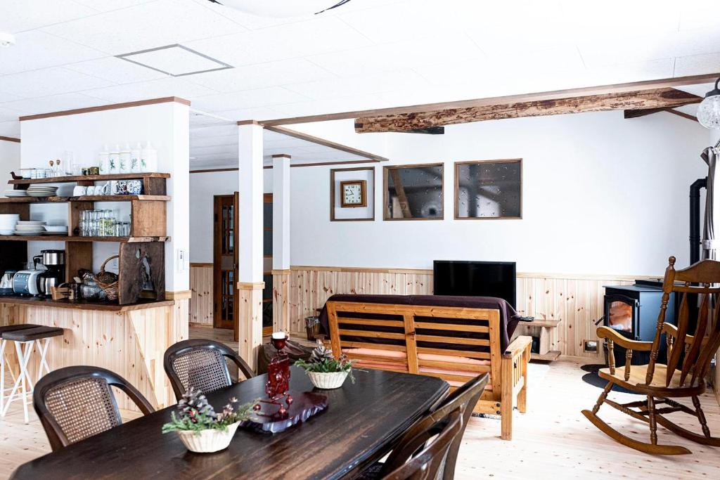 a living room with a wooden table and chairs at Lakeside HANARE in Yuzawa