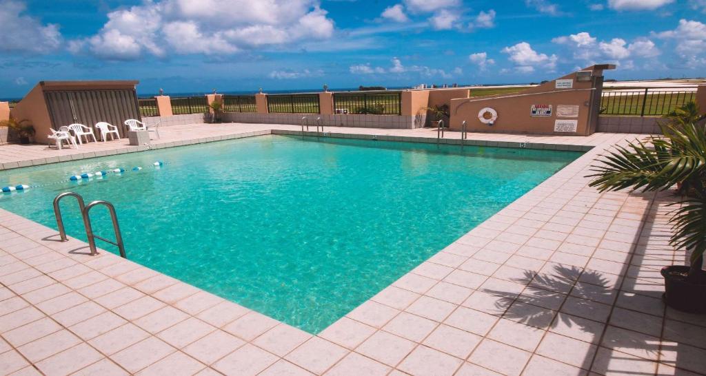 una piscina de agua azul en un edificio en SureStay Hotel by Best Western Guam Airport South, en Tamuning