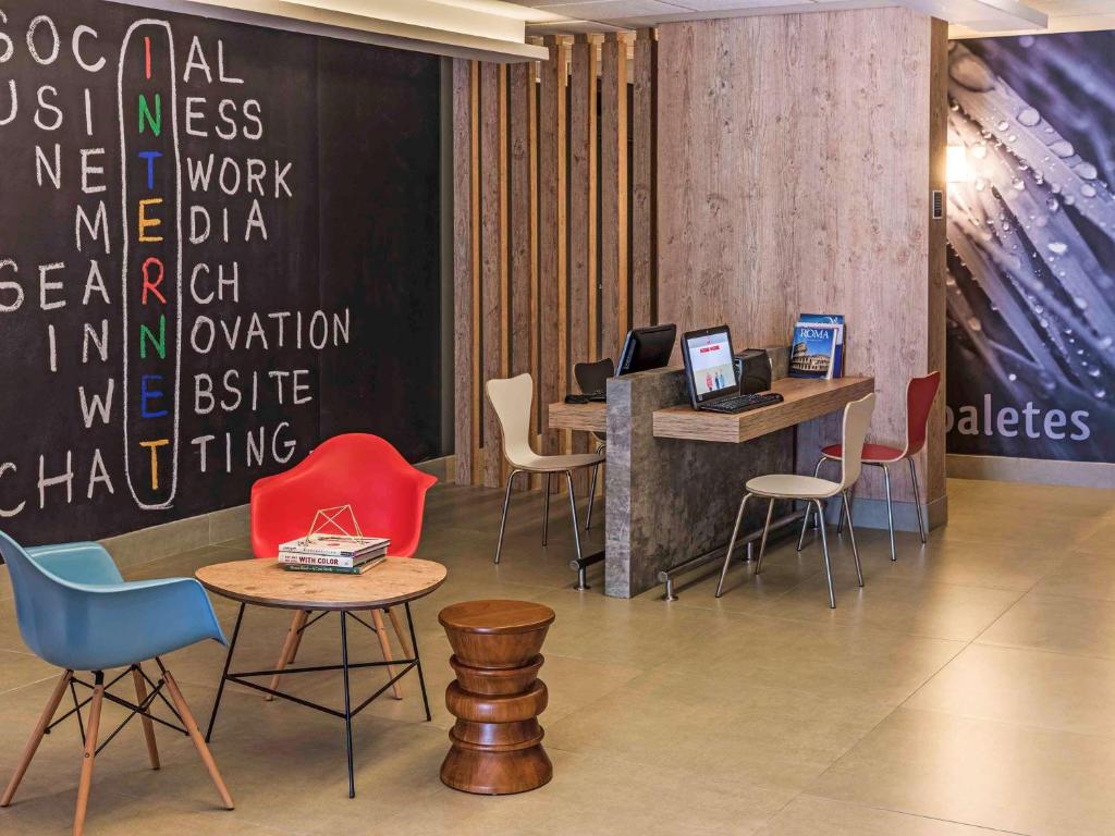 a lobby with tables and chairs and a wall with words at ibis Santos Valongo in Santos