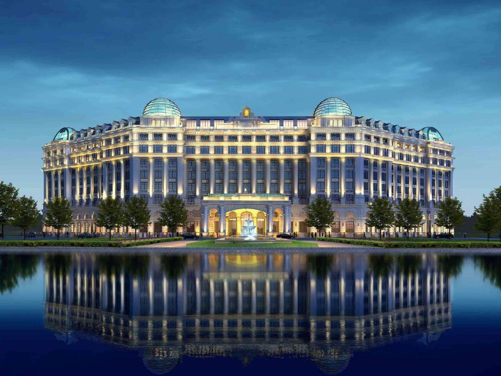 a large building with a reflection in the water at Sofitel Shanghai Hongqiao in Shanghai