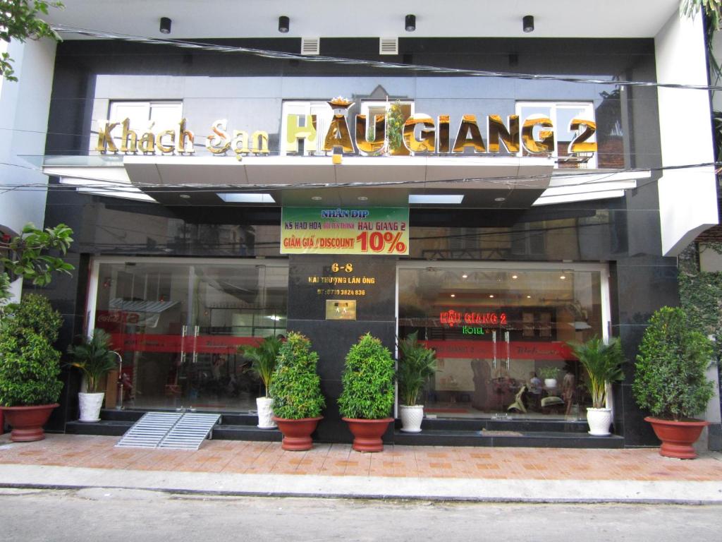 a store front of a restaurant with potted plants in front at Hau Giang 2 Hotel in Can Tho