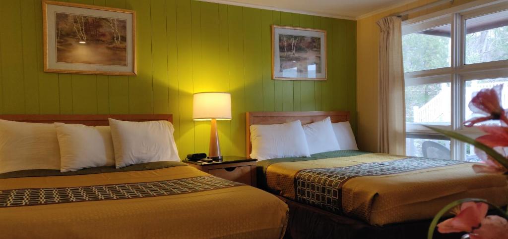 Habitación de hotel con 2 camas y ventana en Pinebrook Motel, en Lake George