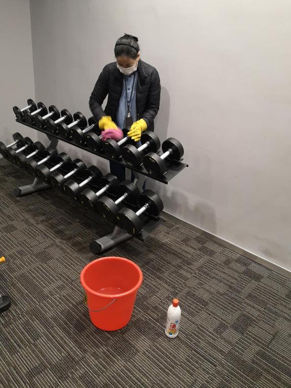 a person with a mask on sitting on a bench in a gym at Sincere Residence Changfeng - Changfeng Ecological Business District - Near Exit 3 of Changfeng Park Station on Subway Line 15 in Shanghai