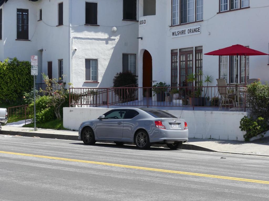 um carro prateado estacionado ao lado de uma rua em Wilshire Orange Hotel em Los Angeles