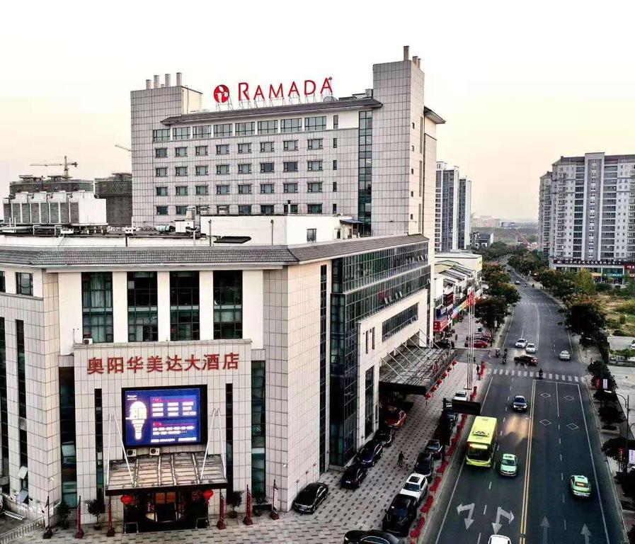 un edificio con un cartel en la parte superior junto a una calle en Ramada Changzhou en Changzhou