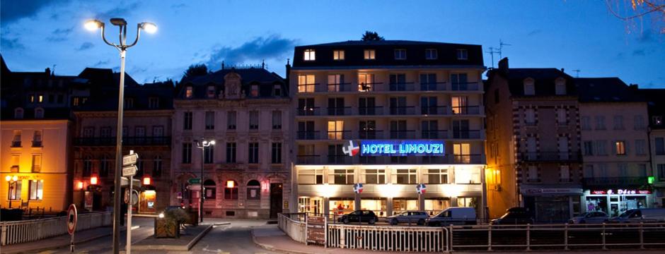 a group of buildings in a city at night at Hôtel Limouzi Tulle Centre in Tulle