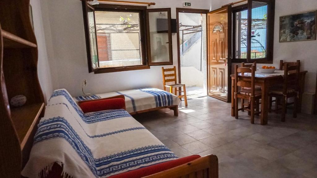 a room with two beds and a table and chairs at Stella Rooms in Kardamyli