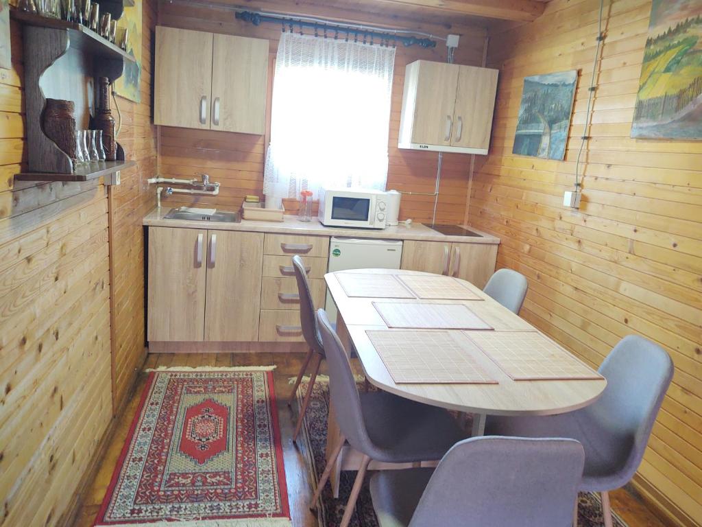 a kitchen with a table and chairs in a room at Dedinski Raj in Golubac