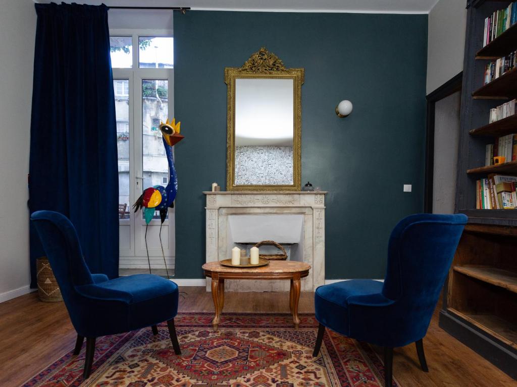 uma sala de estar com 2 cadeiras, uma mesa e um espelho em Babbu Hotel em Bastia