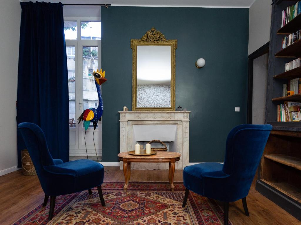 a living room with two chairs and a table and a mirror at Babbu Hotel in Bastia