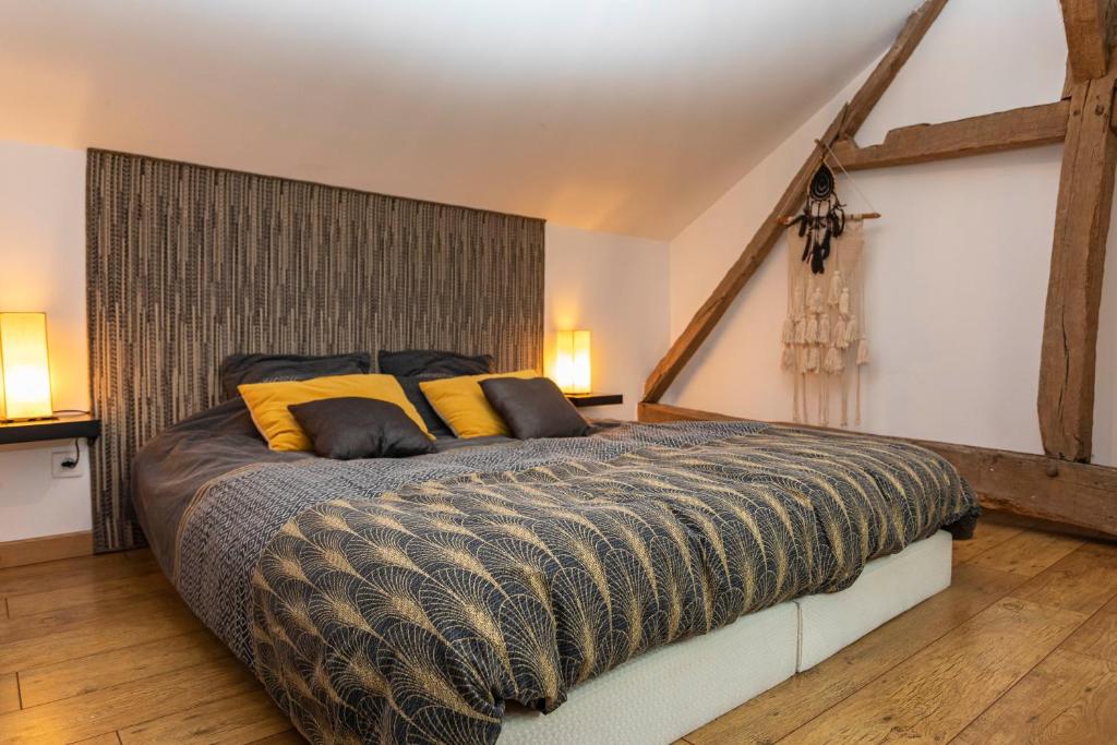 ein Schlafzimmer mit einem großen Bett mit gelben Kissen in der Unterkunft BELLILOIRE, Chambre à la campagne in Belligné