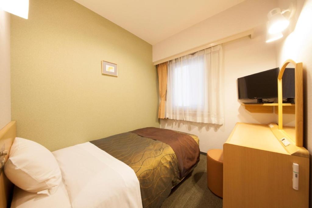 a hotel room with two beds and a television at Hotel Grand City in Tokyo