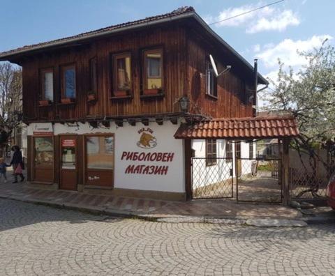 a wooden building with a sign in front of it at Къща Чалъкови in Tryavna