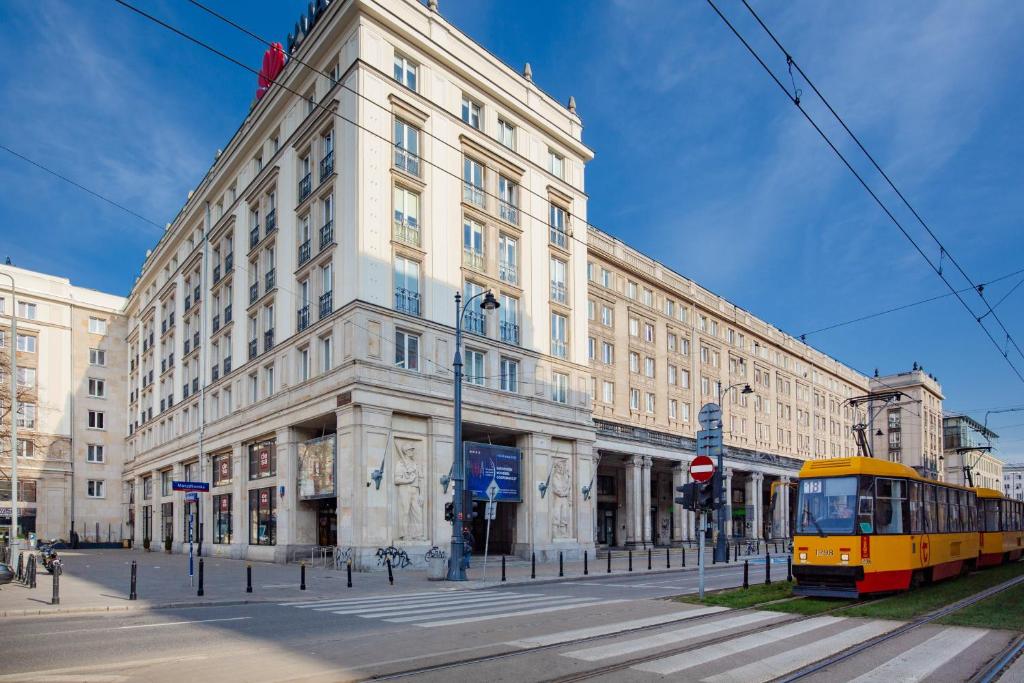 un bus jaune garé devant un bâtiment dans l'établissement Apartment Warsaw City Center, à Varsovie