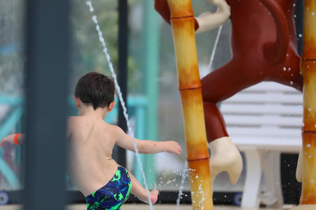 un jeune garçon jouant dans un parc aquatique dans l'établissement CAMPING PARADIS Domaine Oyat, à Le Fenouiller