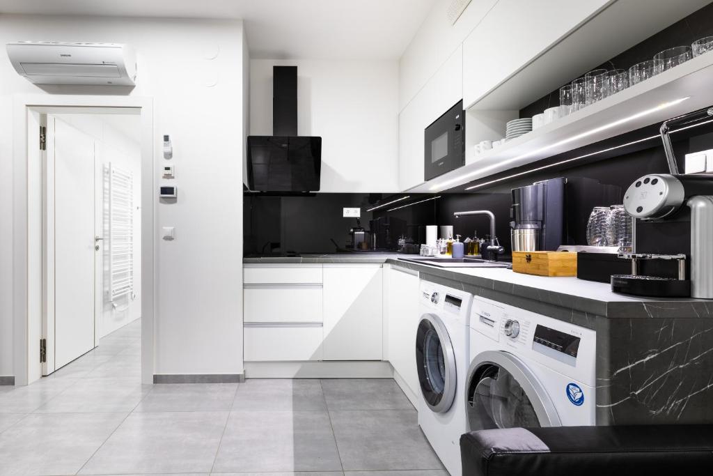 a white kitchen with a washing machine in it at Gabriel´s Apartments in Vienna