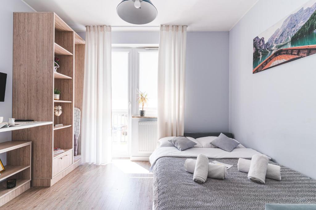biała sypialnia z łóżkiem z poduszkami w obiekcie Apartamenty Novomiejska 17 w mieście Lublin