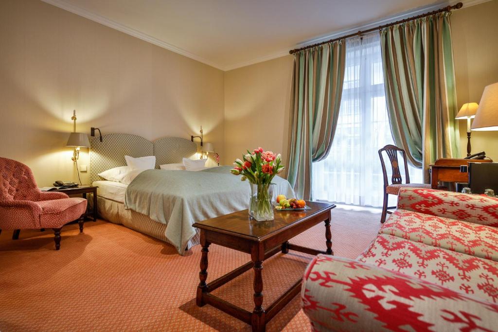 a hotel room with a bed and a table with flowers at Hotel Stadt Hamburg in Westerland