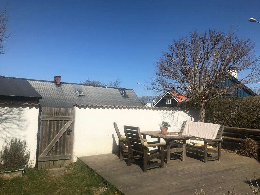 un patio con mesa, sillas y una valla en Botanikerns hus, en Löderup