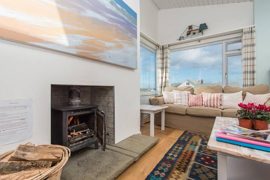 a living room with a fireplace and a couch at TARIAN HAF-3 BED-SEA VIEW BUNGALOW-TREARDDUR BAY in Trearddur
