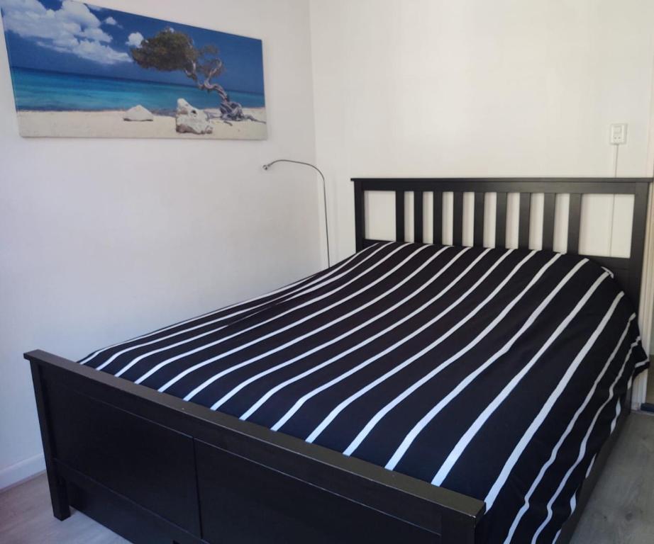 Un dormitorio con una cama con rayas azules y blancas. en Jordaan Canal View Apartment, en Ámsterdam