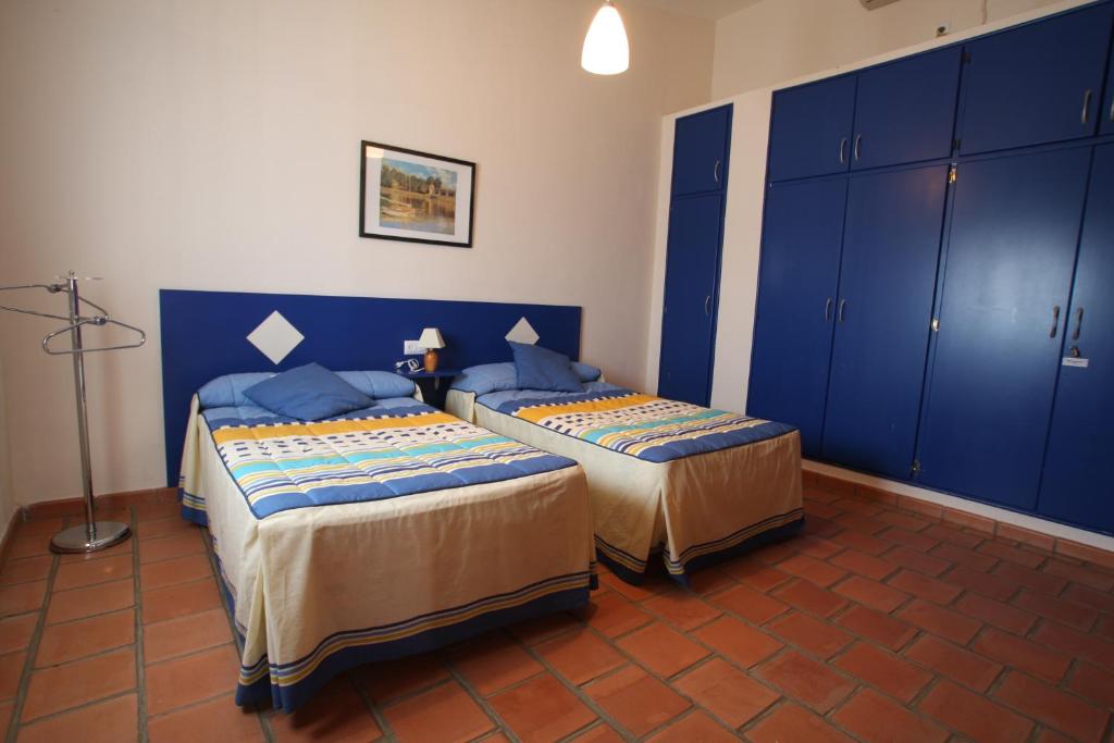 2 letti in una camera con armadi blu di Casa Rural Apartamento "Isla del Zújar" a Castuera