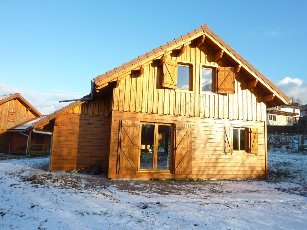 a wooden house with snow on the ground at Lovely chalet in Vosges with shared pool in Zhezdi