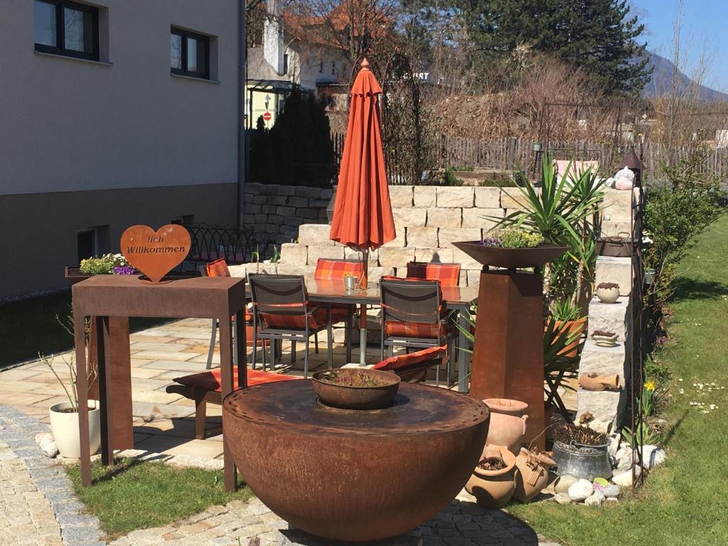 eine Terrasse mit einem Tisch, einem Sonnenschirm und einem Hydranten in der Unterkunft Ferienwohnung Müller-Aydemir in Kiefersfelden