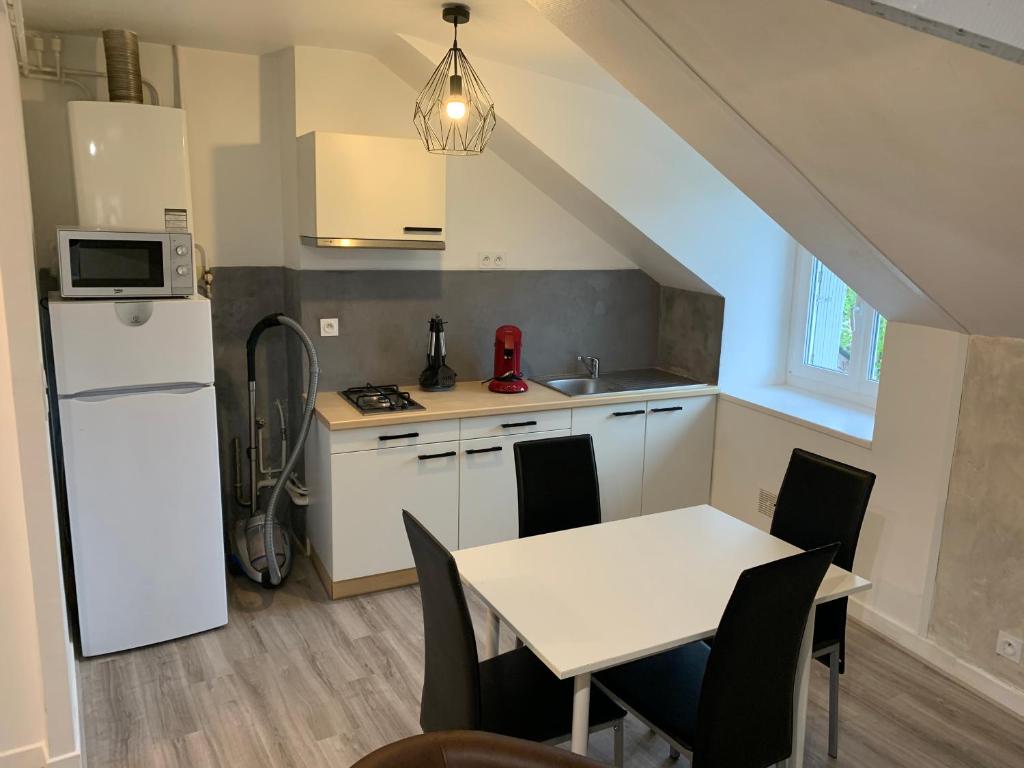 a kitchen with a table and a white refrigerator at Rue de la banque centre ville Rodez in Rodez