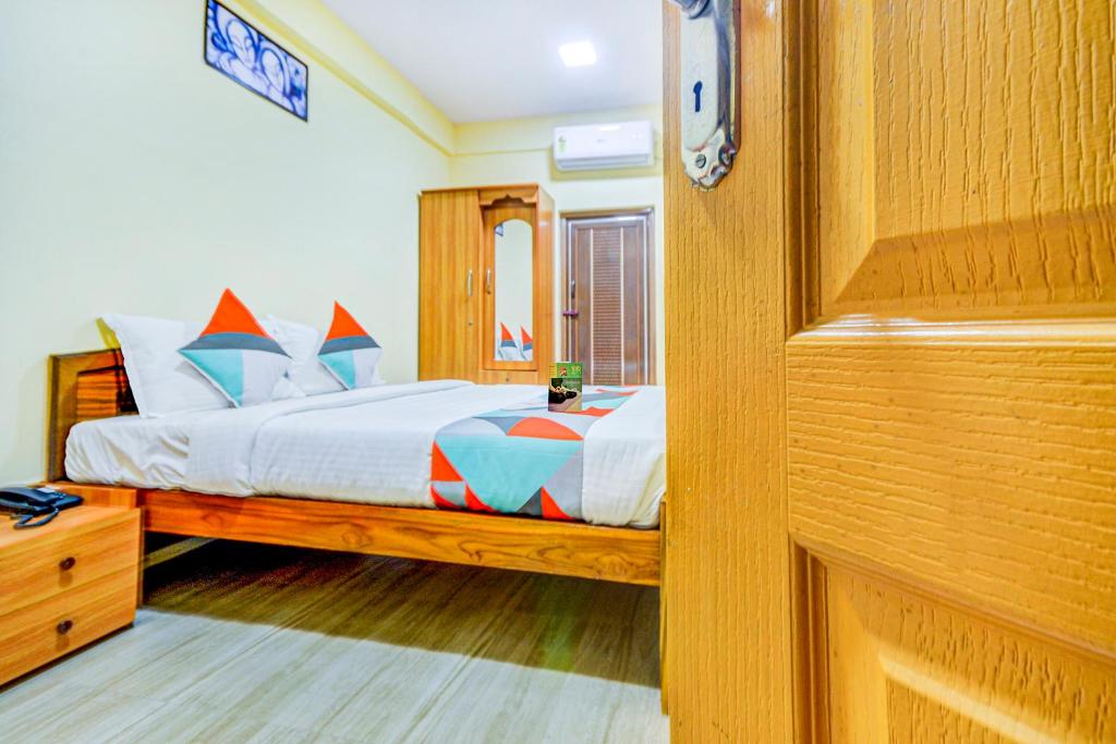 um quarto com uma cama e um espelho em FabExpress Ragu Residency em Coimbatore