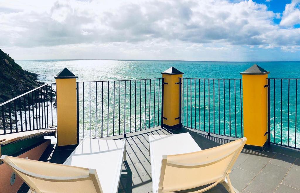 a balcony with two chairs and a view of the ocean at La Polena Camere Vernazza - Suite vista mare in Vernazza