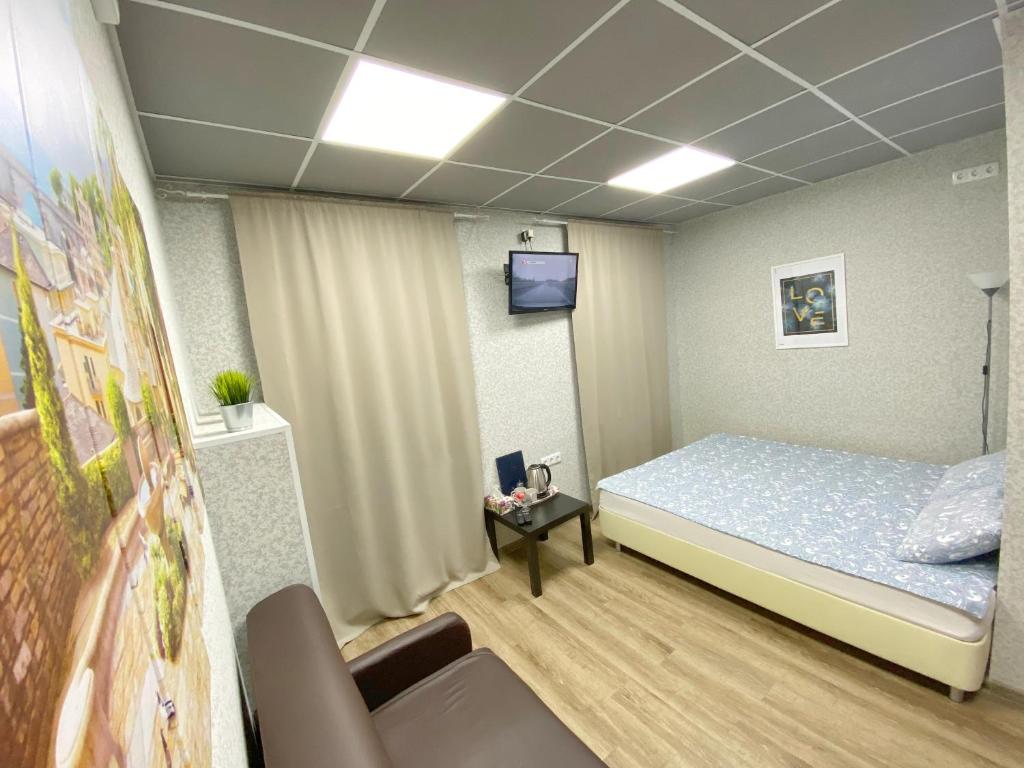 モスクワにあるHotel Strominkaのベッド1台とテレビが備わる客室です。