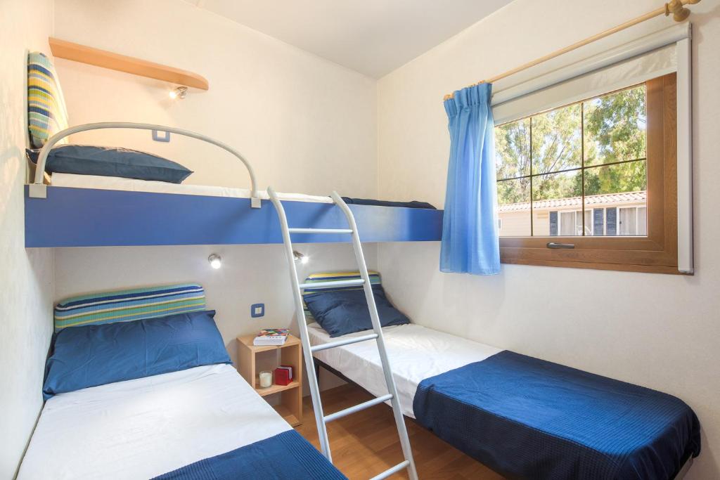 Łóżko lub łóżka w pokoju w obiekcie Camping Village Laguna Blu