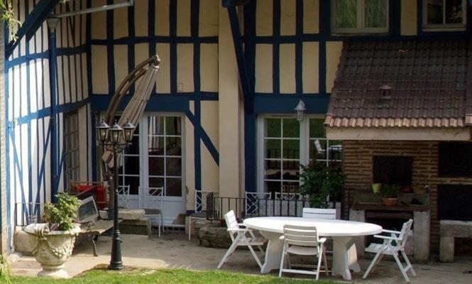 une table et des chaises devant un bâtiment dans l'établissement Les Wyllos, à Thiéblemont-Farémont