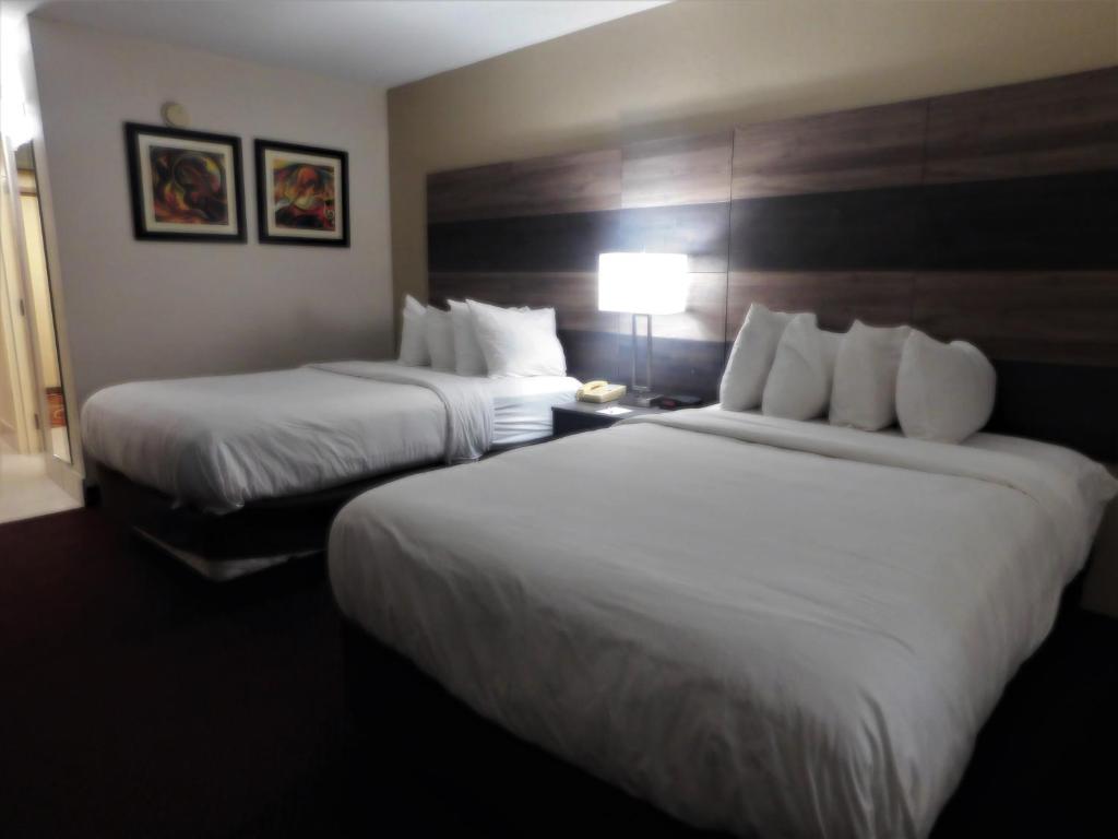 una camera d'albergo con due letti e una lampada di Americas Best Value Inn Winston-Salem a Winston-Salem