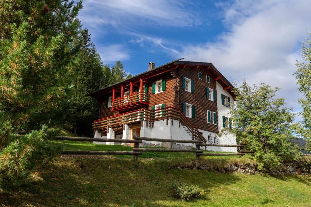 a house on top of a hill with a fence at QC House - Chalet con Sauna in Santa Caterina Valfurva