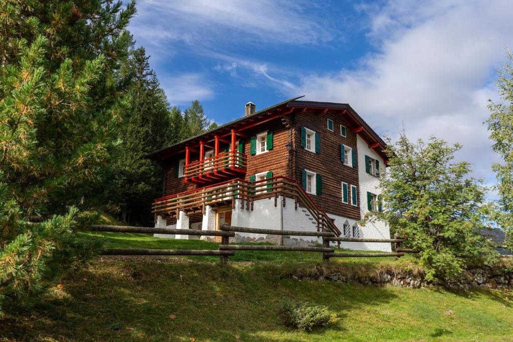 dom na szczycie wzgórza z płotem w obiekcie QC House - Chalet con Sauna w mieście Santa Caterina Valfurva