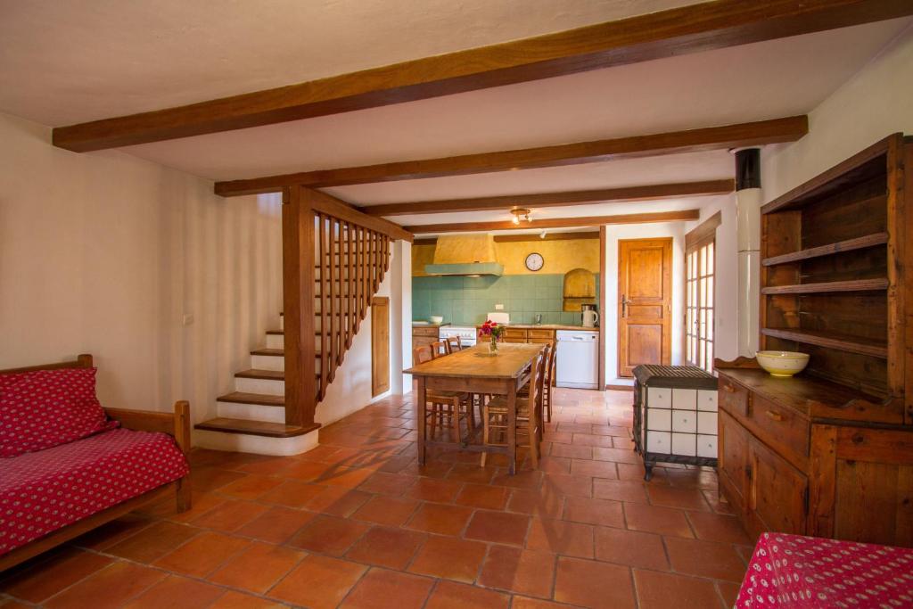 een woonkamer met een keuken en een tafel en stoelen bij L'Oubradou Mas de charme shared pool in Provence nature and calm in Flayosc
