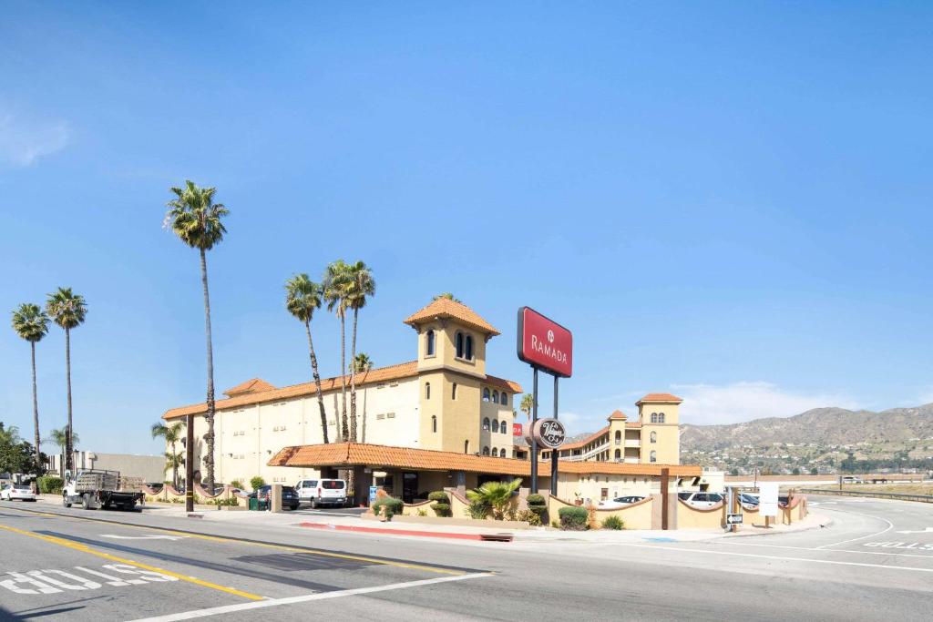 un hôtel situé sur le côté d'une route bordée de palmiers dans l'établissement Ramada by Wyndham Burbank Airport, à Burbank