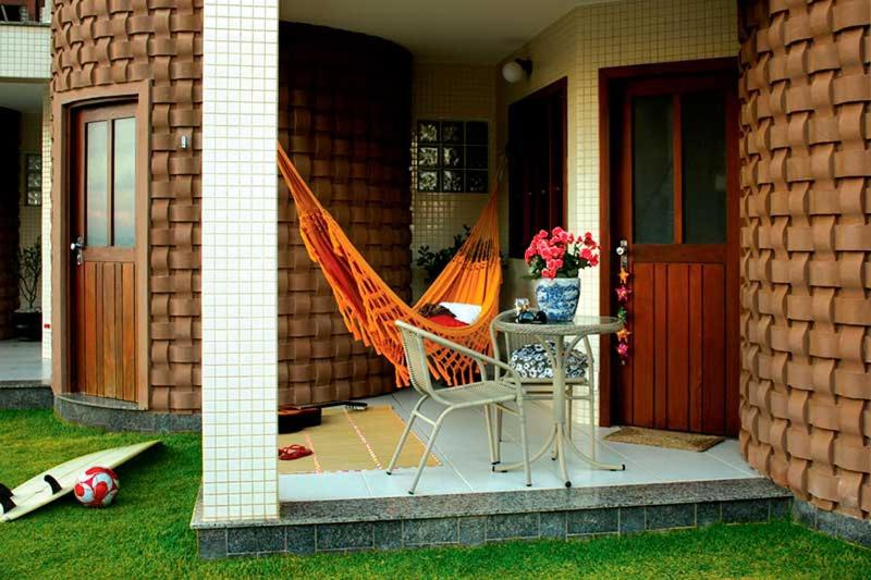 a patio with a chair and a table on a house at Pousada Restinga Apart Service- Aeroporto in Lauro de Freitas