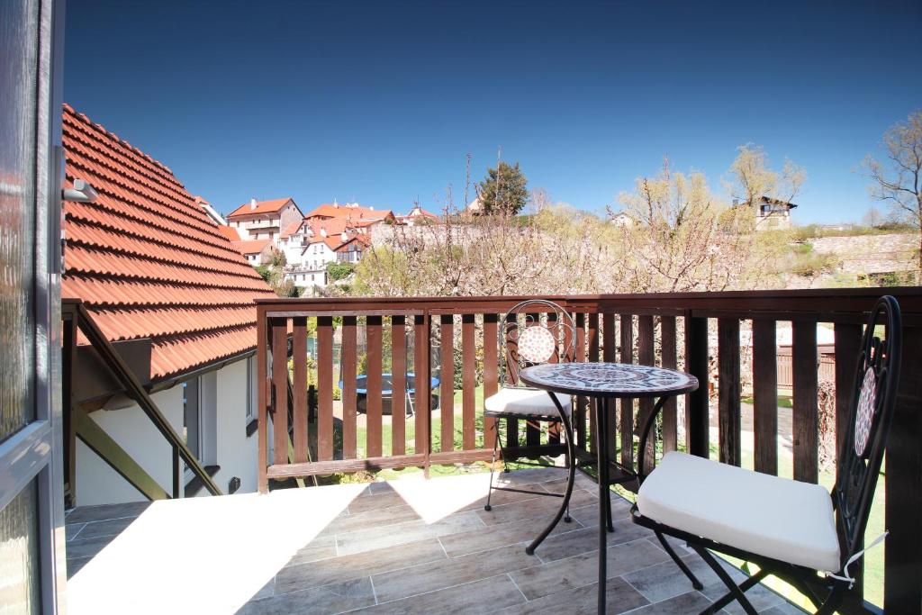 a patio with a table and chairs on a balcony at Pension Adel in Český Krumlov