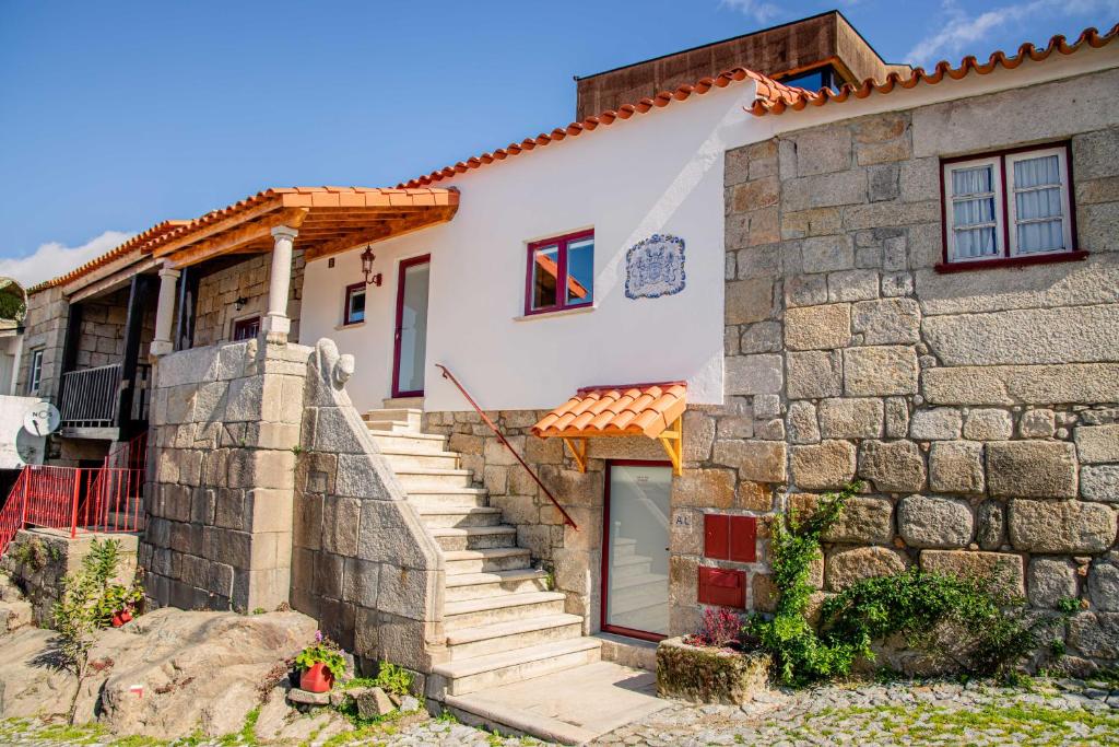 een huis met een stenen muur bij Casa do Leão in Marialva