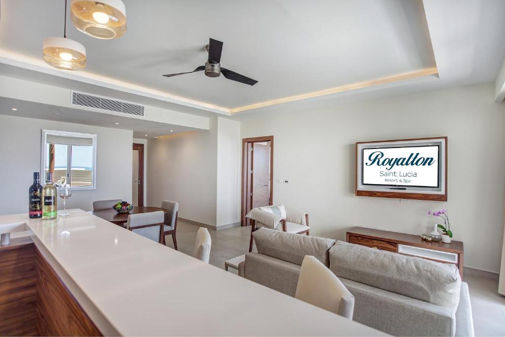 Suite living area with kitchen counter, seating, ocean view through window.