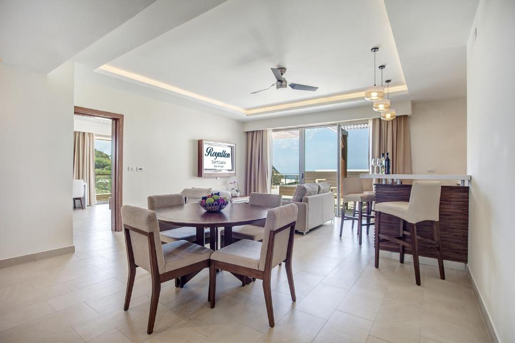 Suite interior with round dining table, living area, and sea view through windows.