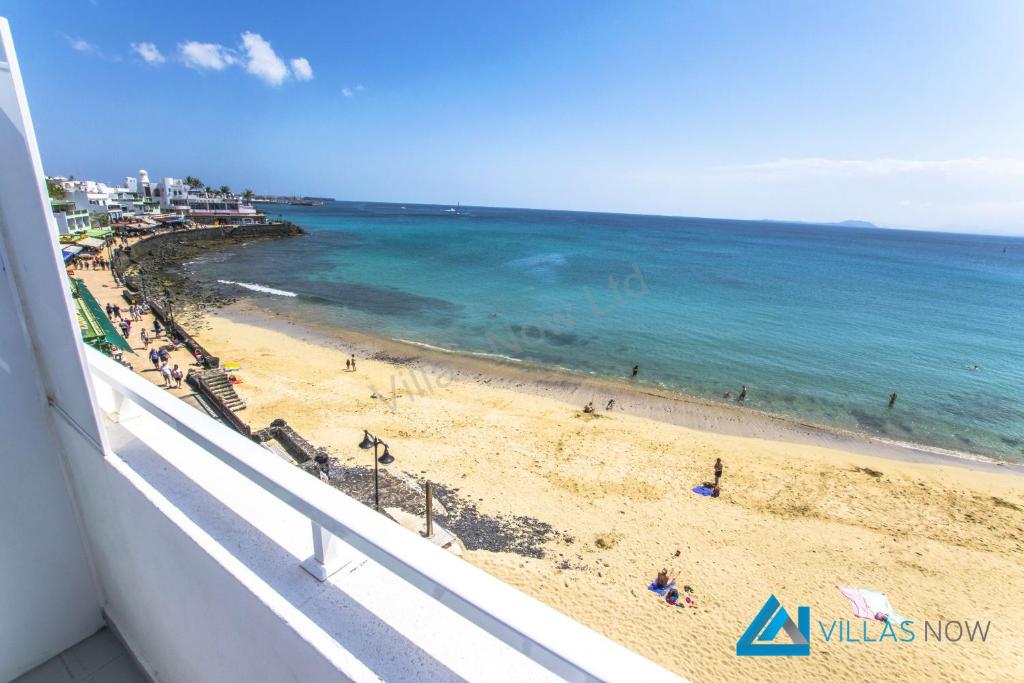 Una vista de una playa y el océano desde un balcón. en Apartments Vista Maritima By Villas Now Ltd, en Playa Blanca