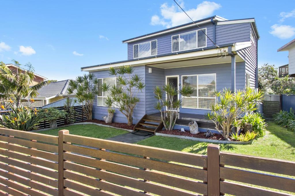 una casa con una valla delante en The Blue Cottage, en Ulladulla
