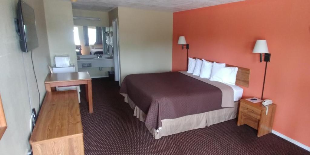 Habitación de hotel con cama grande y TV en Mission Inn, en San Antonio