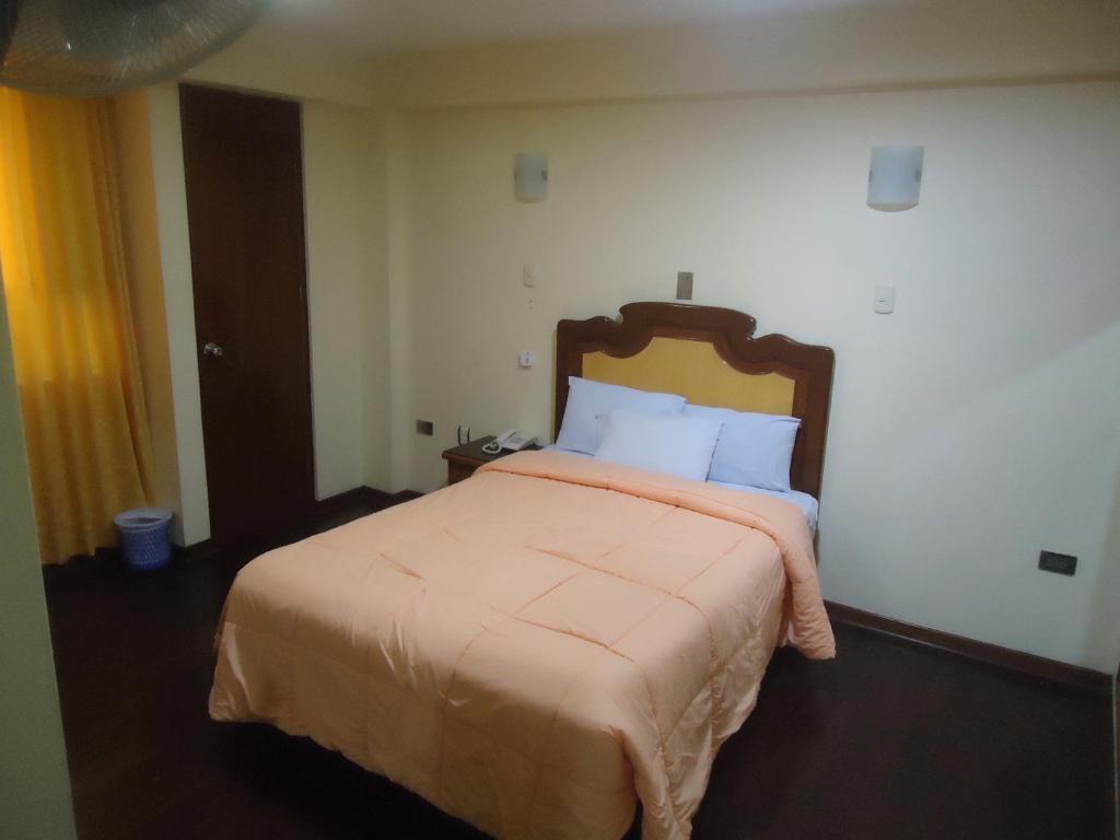 ein Schlafzimmer mit einem großen Bett in einem Zimmer in der Unterkunft Hotel Panamericano in Lima