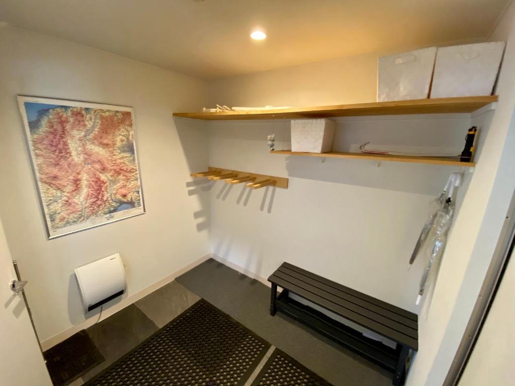 a small room with a bench and a painting on the wall at ZEN CHALETS Hakuba in Hakuba